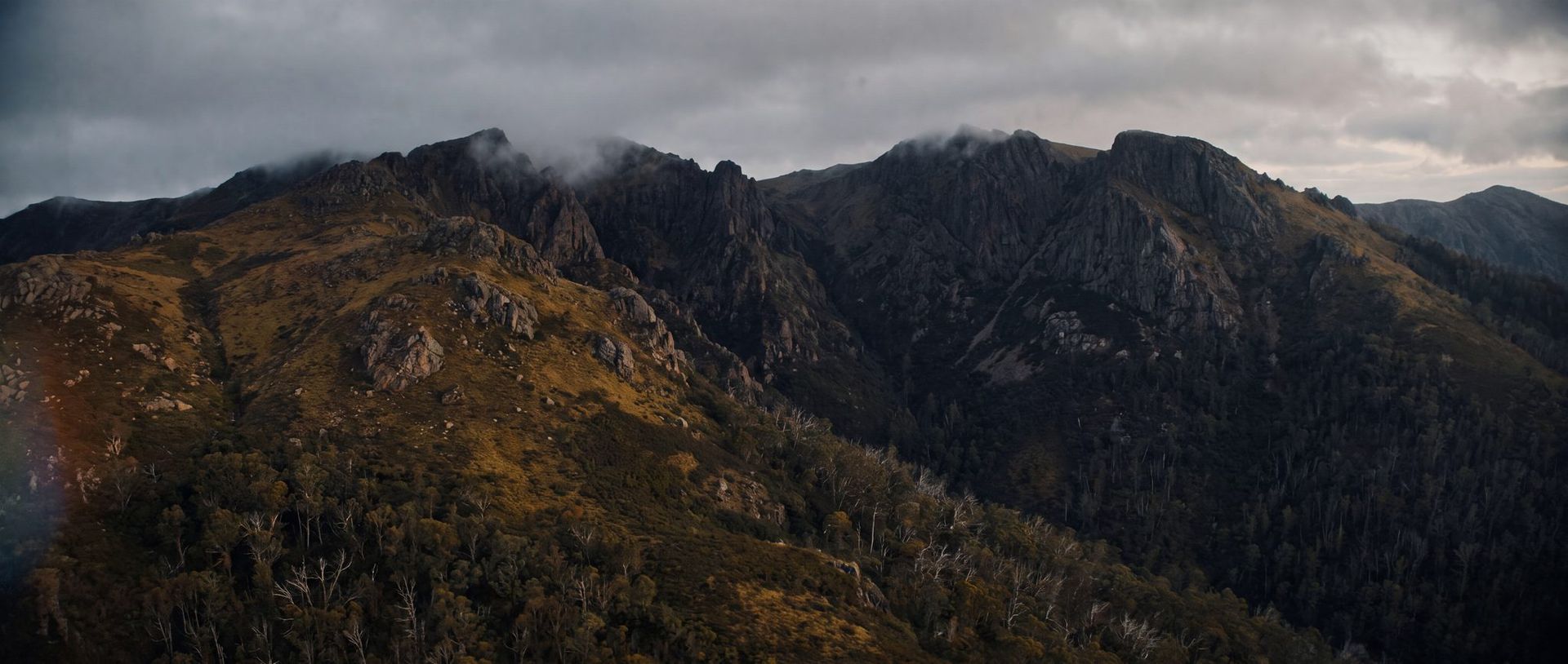 Bare granite ranges and windswept alpine wilderness under low cloud.