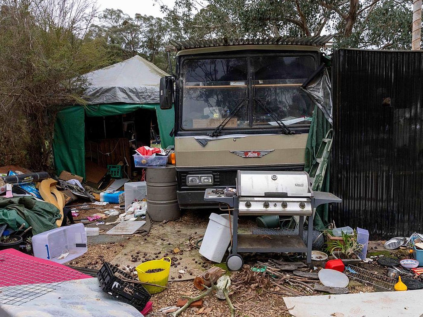 The bus Freeman lived in with his family, awning and camp around it.