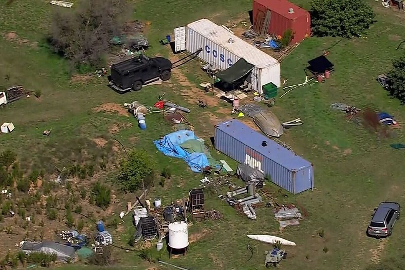Aerial view of the Thologolong property: shipping containers, tarpaulins and an armoured vehicle.