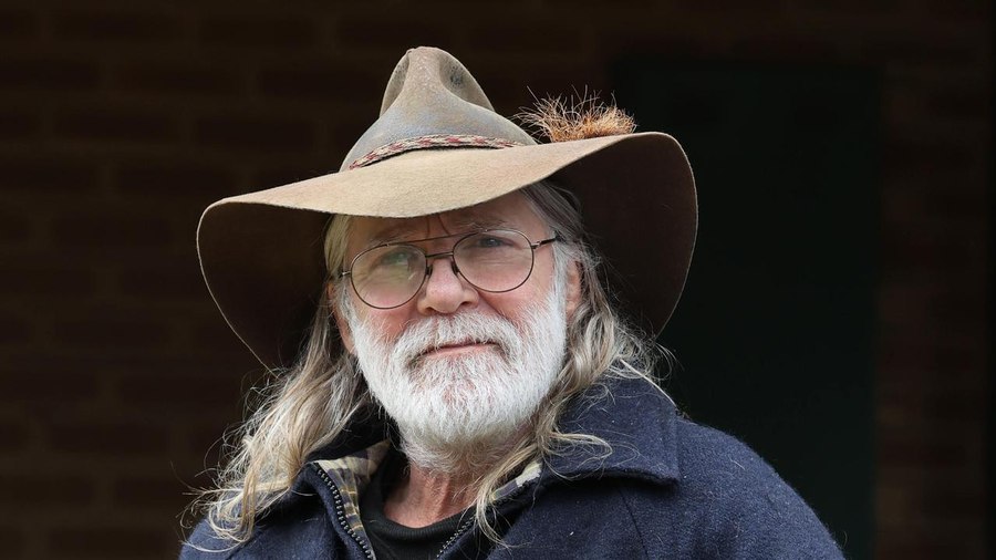 Steve Mallett in a battered bush hat, looking into the camera.